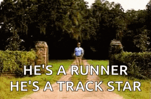 a man is running down a dirt road with trees in the background .