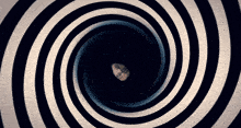 a black and white hypnotic spiral with a person 's face in the middle