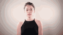 a young woman in a black top is making a funny face .