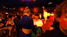 a group of people dancing in a dark room with a cbs logo on the bottom