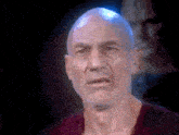 a close up of a bald man with a beard making a funny face .