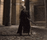 a man in a black coat is holding a sword in a room