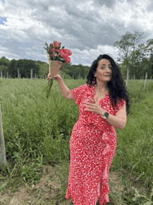 a woman in a red dress holding a bouquet of flowers