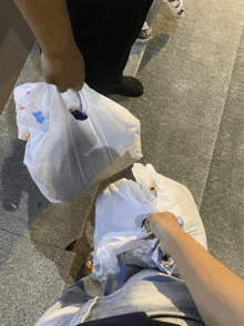 a person is holding a plastic bag that says ' a ' on it