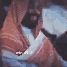 a man with a beard wearing a scarf is holding a gun in his hand .