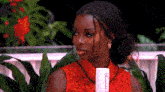 a woman in a red dress is holding a white bottle that says beauty