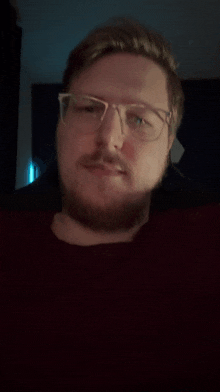 a man with glasses and a beard is making a face