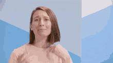 a woman with her arms outstretched in front of a blue wall with the elite daily logo in the corner