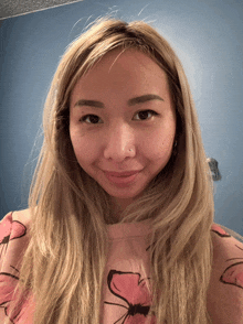 a woman wearing a pink shirt with a butterfly on it