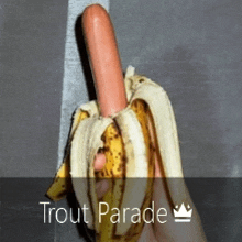 a person is holding a banana with a hot dog inside of it