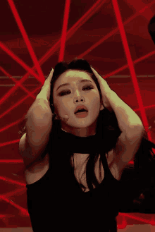a woman in a black top is dancing with her hands up