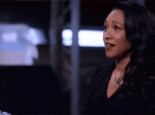 a woman in a black shirt and necklace is talking to another woman .