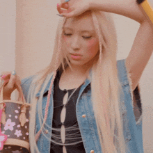 a woman with blonde hair and pink braids is holding a louis vuitton purse