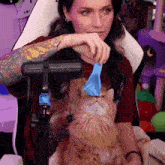a woman playing with a cat with a blue balloon