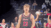 a basketball player with the number 23 on his jersey stands in front of a crowd
