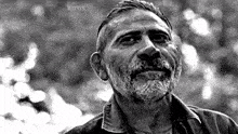 a black and white photo of a man with a beard and mustache looking up .