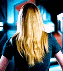 the back of a woman 's head with long blonde hair