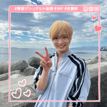 a young man giving a peace sign in front of a blue sky