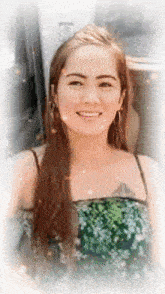 a woman with long hair is smiling and wearing a green top .