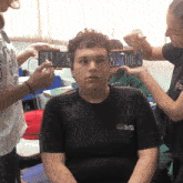 a boy wearing a black shirt that says ' aoc ' on it is being photographed