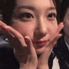 a close up of a woman making a face with her hands on her face .