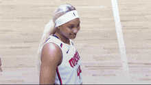 a female basketball player wearing a white headband and a jersey that says milwaukee on it