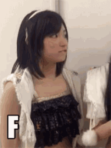 a girl standing next to another girl with the letter f above her head