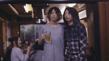 a man in a plaid shirt holds a glass in his hand