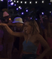 a man in a hat is dancing with a woman in a blue tank top