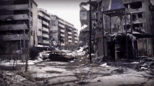 a black and white photo of a destroyed city with a car in the foreground