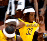 a basketball player wearing a yellow jersey with the number 33 on it