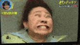 a television screen shows a woman making a funny face with chinese writing on the bottom