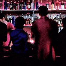 a man in a red suit is drinking from a bottle in front of a bar