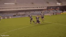 a soccer player is kneeling on the field with his arms outstretched .