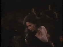 a man is holding a woman in a dark room .