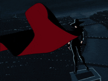 a statue of a man in a cape is standing on a block