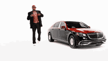 a man is standing next to a black and red mercedes