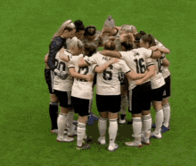 a group of soccer players are huddled together on the field