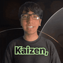 a man wearing glasses and a black shirt with kaizen on it