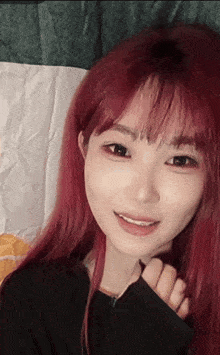 a girl with red hair and black eyes is smiling