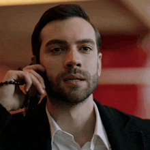 a man with a beard is talking on a cellphone