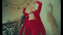a woman in a red coat is standing on stairs