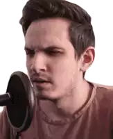 a man is singing into a microphone and making a funny face