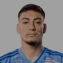 a man with a beard wears a blue shirt with white stripes