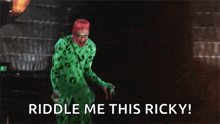 a man in a green costume says " riddle me this ricky " in a dark room