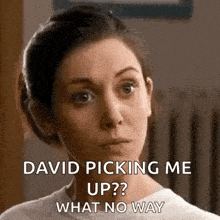 a woman is looking at the camera with a serious look on her face .