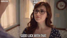 a woman wearing glasses is talking to a man in a room and saying `` good luck with that '' .