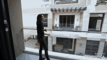 a woman standing on a balcony with the words made in animatica on the bottom right