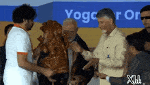 a group of people standing in front of a sign that says yoga