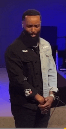 a man with a beard is wearing a black shirt that says god on it